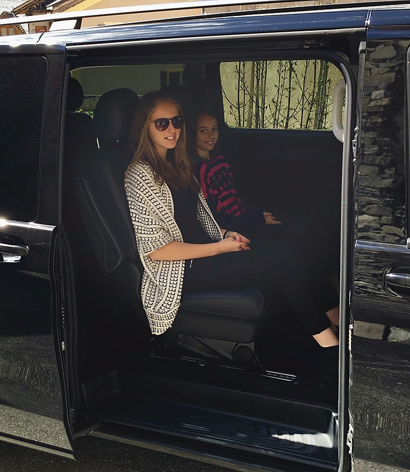 Two young passengers comfortably seated inside a Leocleme Prestige Mercedes van.