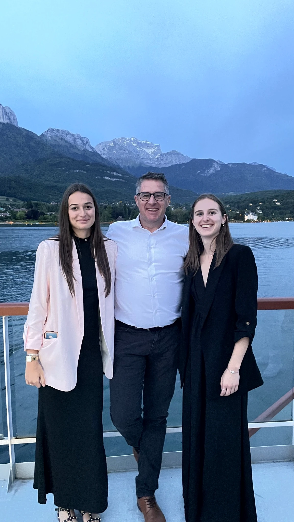 Founder of Leocleme Prestige with his daughters Léonie and Clémentine beside an Alpine lake.