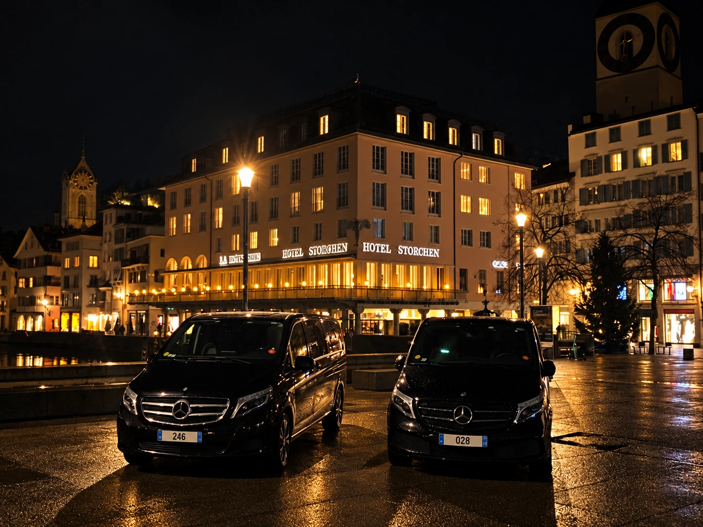 Two Leocleme Prestige Mercedes V-Class vans outside Hotel Storchen in Zurich at night.